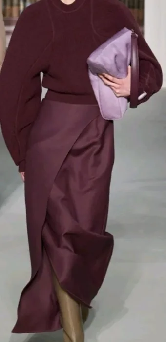 Burgundy knit sweater and wrap skirt with a lilac clutch, on the runway